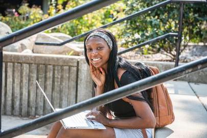 Female student sitting and studying outdoors.