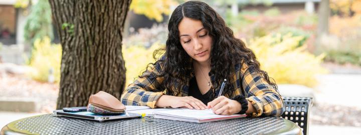 Student writing outdoors